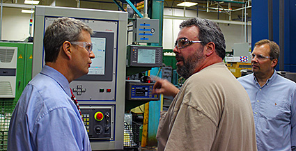 Rep. Bill Huizenga; Kaydon associate Steve Elwell; and John Saber, Kaydon director of aerospace and defense, review grinding operations.
